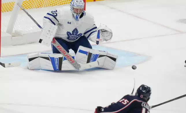 Columbus Blue Jackets defenseman Dante Fabbro (15) shoots and scores on Toronto Maple Leafs goaltender Cayden Primeau (30) in the second period of an NHL hockey game in Columbus, Wednesday, Oct. 29, 2025. (AP Photo/Sue Ogrocki)