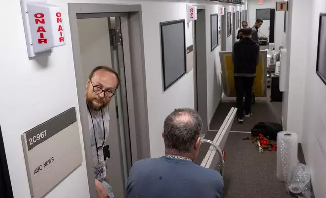 Members of the media pack up their belongings in the press area of the Pentagon, Wednesday, Oct. 15, 2025 in Washington. (AP Photo/Kevin Wolf)