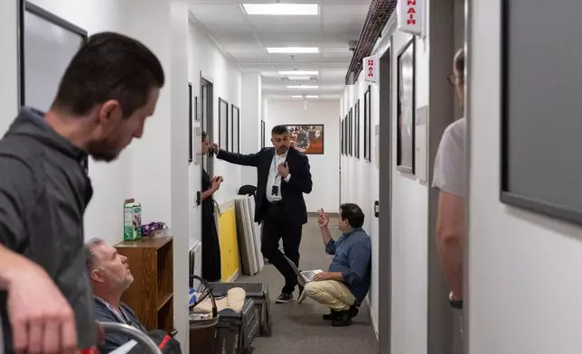 Members of the media pack up their belongings in the press area of the Pentagon, Wednesday, Oct. 15, 2025 in Washington. (AP Photo/Kevin Wolf)