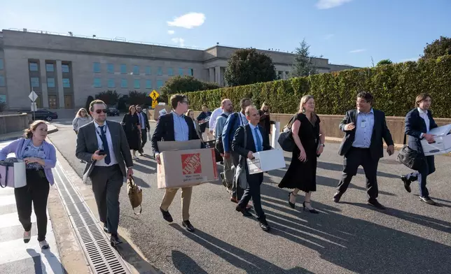 Members of the Pentagon press corp carry their belongings out of the Pentagon after turning in their press credentials, Wednesday, Oct. 15, 2025 in Washington. (AP Photo/Kevin Wolf)