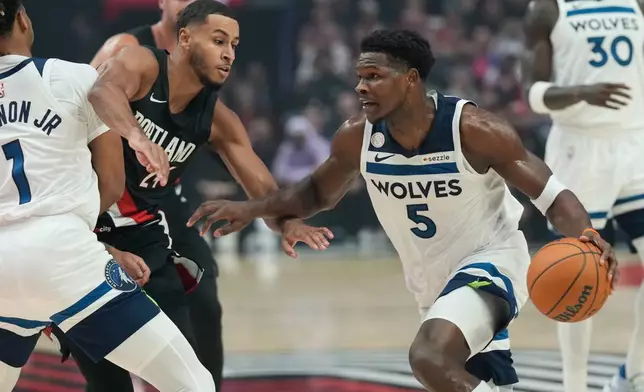 Minnesota Timberwolves guard Anthony Edwards (5) drives past Portland Trail Blazers forward Kris Murray (24) during the first half of an NBA basketball game on Wednesday, Oct. 22, 2025, in Portland, Ore. (AP Photo/Jenny Kane)