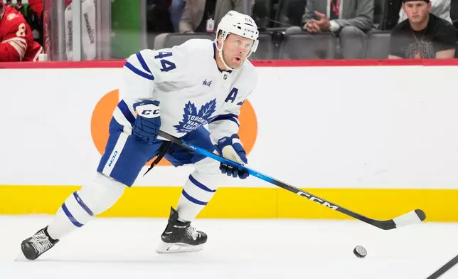 Toronto Maple Leafs defenseman Morgan Rielly controls the puck during the first period of an NHL hockey game against the Detroit Red Wings, Saturday, Oct. 11, 2025, in Detroit. (AP Photo/Ryan Sun)
