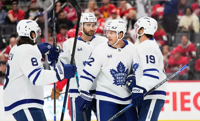 Toronto Maple Leafs center Calle Jarnkrok, right, celebrates with, from left to right, defenseman Chris Tanev, center Nicolas Roy, and defenseman Jake McCabe after scoring during the first period of an NHL hockey game against the Detroit Red Wings, Saturday, Oct. 11, 2025, in Detroit. (AP Photo/Ryan Sun)