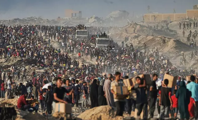 People carry sacks and boxes of food and humanitarian aid that was unloaded from a World Food Program convoy that had been heading to Gaza City in the northern Gaza Strip, Monday, June 16, 2025. (AP Photo/Jehad Alshrafi)