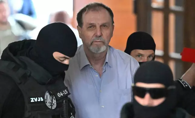 FILE -Juraj Cintula, center, is escorted to the Specialized Criminal Court in Banská Bystrica, Slovakia, July 8, 2025, for a trial over last year's attempted assassination of Slovakia's populist Prime Minister Robert Fico. (Vaclav Salek/CTK via AP, File)