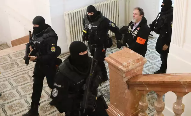 Juraj Cintula, who shot and seriously injured Prime minister of Slovakia Robert Fico last year, is convoyed at the Specialized Criminal Court in Banska Bystrica, Slovakia, Tuesday, Oct. 21, 2025. (Jan Kroslak/TASR via AP)