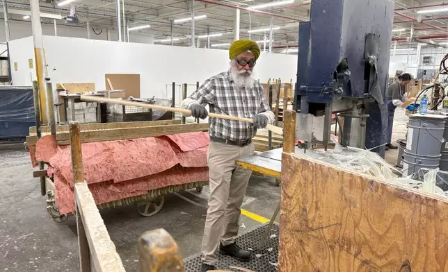A worker makes wooden hockey sticks at the Roustan Hockey factory, which is the last major manufacturer of hockey sticks in Canada on Aug. 27, 2025 in Brantford, Ontario. (AP Photo/Kelvin Chan)