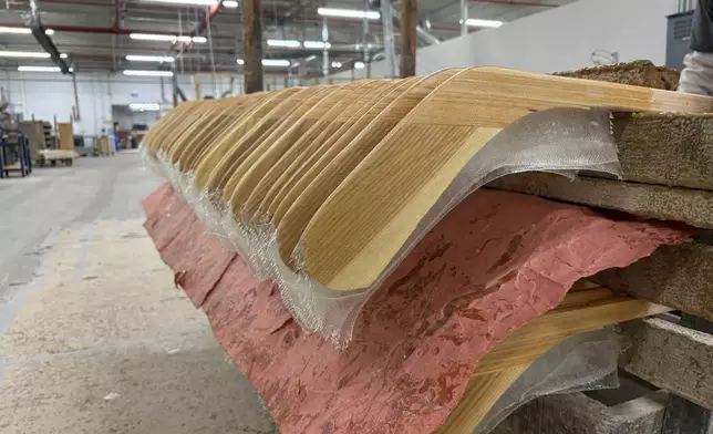 Wooden hockey sticks are stacked as they move along the assembly line at the Roustan Hockey factory, which is the last major manufacturer of hockey sticks in Canada on Aug. 27, 2025 in Brantford, Ontario. (AP Photo/Kelvin Chan)