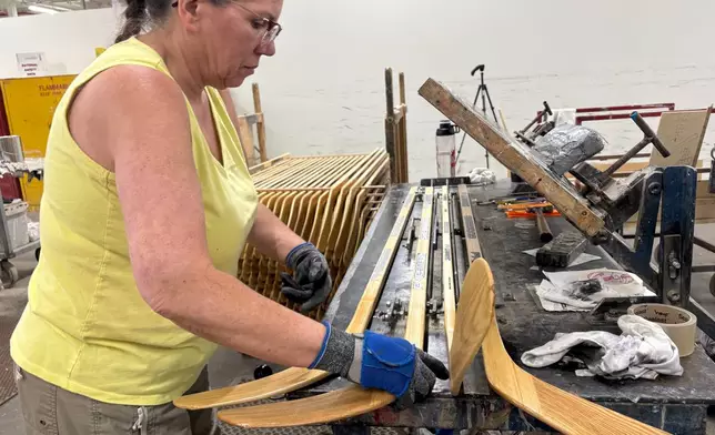 A worker makes wooden hockey sticks at the Roustan Hockey factory, which is the last major manufacturer of hockey sticks in Canada on Aug. 27, 2025 in Brantford, Ontario. (AP Photo/Kelvin Chan)