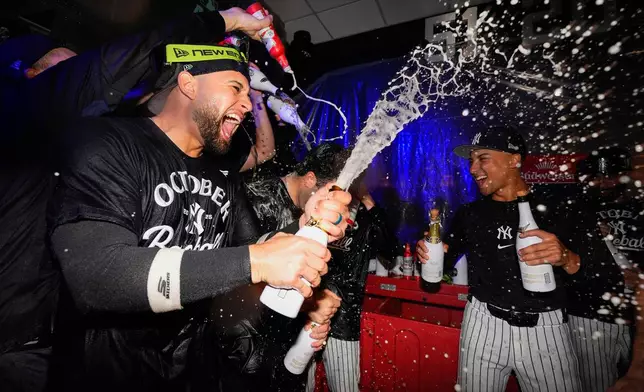 TheNew York Yankees celebrate in the locker room after defeating the Boston Red Sox in Game 3 of an American League wild-card baseball playoff series, Thursday, Oct. 2, 2025, in New York. (AP Photo/Yuki Iwamura)
