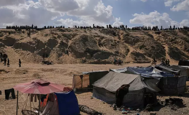 Displaced Palestinians walk along the coastal road near Wadi Gaza in the central Gaza Strip, moving toward northern Gaza, Friday, Oct. 10, 2025, after Israel and Hamas have agreed to a pause in their war and the release of the remaining hostages. (AP Photo/Abdel Kareem Hana)