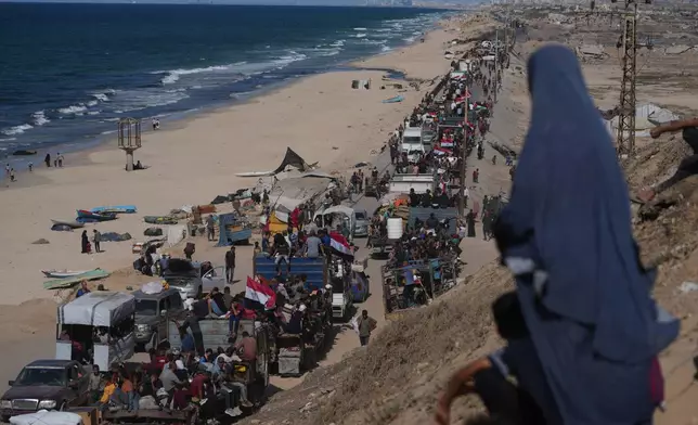 Displaced Palestinians ride on trucks loaded with belongings and wave Egyptian and Palestinian flags as they travel along the coastal road near Wadi Gaza in the central Gaza Strip, moving toward Gaza city, Saturday, Oct. 11, 2025, after Israel and Hamas agreed to a pause in their war and the release of the remaining hostages. (AP Photo/Jehad Alshrafi)