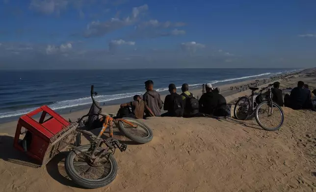Displaced Palestinians gather on the coastal road near Wadi Gaza in the central Gaza Strip, Friday, Oct. 10, 2025, after Israel and Hamas have agreed to a pause in their war and the release of the remaining hostages. (AP Photo/Abdel Kareem Hana)