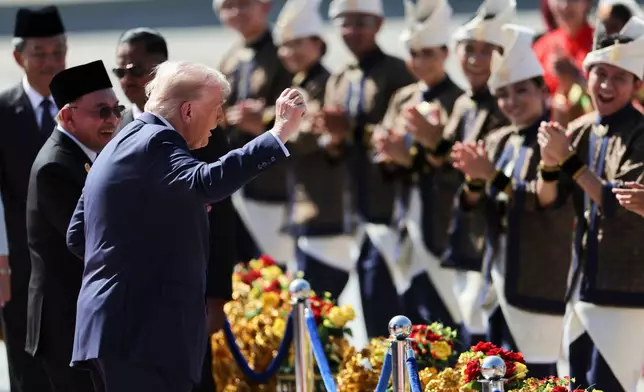 U.S. President Donald Trump reacts to dancing performers during a welcoming ceremony after arriving at Kuala Lumpur International Airport, to attend the 47th Association of Southeast Asian Nations (ASEAN) summit in Kuala Lumpur, Malaysia, Sunday, Oct. 26, 2025. (Hasnoor Hussain/Pool Photo via AP)