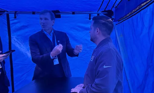 NFL chief medical officer Allen Sills, left, and New York Giants assistant athletic trainer Justin Maher, right, stand inside a blue medical tent Thursday, Oct. 9, 2025, at MetLife Stadium in East Rutherford, N.J. (AP Photo/Stephen Whyno)