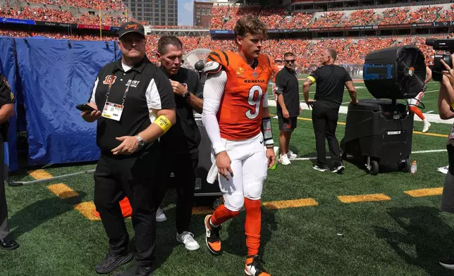 FILE - Cincinnati Bengals quarterback Joe Burrow, center, is exits the medical tent for the locker room after suffering an injury during the second quarter of an NFL football game against the Jacksonville Jaguars, Sept. 14, 2025, in Cincinnati. (AP Photo/Kareem Elgazzar, File)