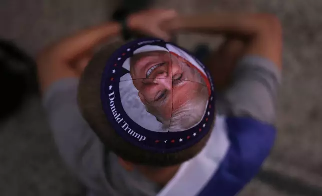 A Jewish man wears a kippah printed with the image of U.S. President Donald Trump during a gathering at a plaza known as hostages square in Tel Aviv, Israel, Monday, Oct. 13, 2025, before the release of Israeli hostages held in Gaza. (AP Photo/Oded Balilty)