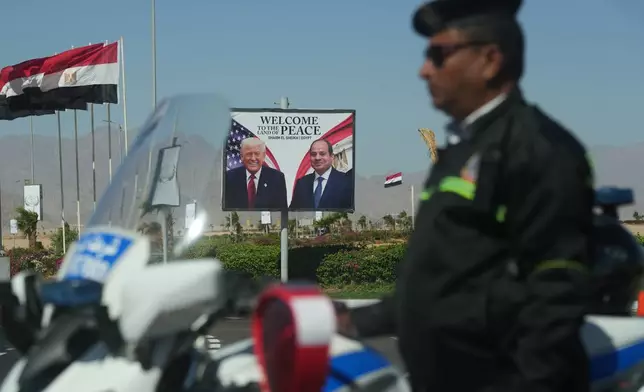 A policeman stands on alert in front of a poster showing Egyptian President Abdel-Fattah el-Sissi and U.S. President Donald Trump at the Red Sea city of Sharm el-Sheikh, Egypt, Monday, Oct. 13, 2025. (AP Photo/Amr Nabil)