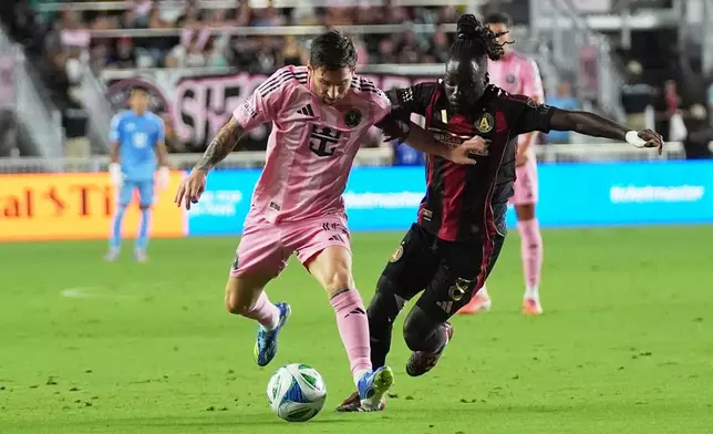 Inter Miami forward Lionel Messi, left, runs with the ball as Atlanta United midfielder Tristan Muyumba, right, defends during the first half of an MLS soccer match, Saturday, Oct. 11, 2025, in Fort Lauderdale, Fla. (AP Photo/Lynne Sladky)