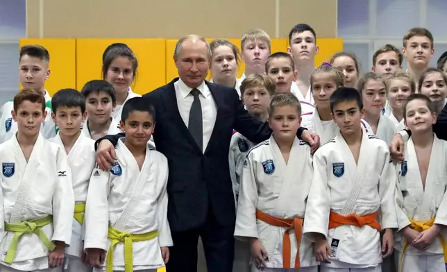FILE - Russian President Vladimir Putin, poses for a photo during a visit to the judo club Turbostroitel leading by coach Anatoly Rakhlin when Putin was a boy in St. Petersburg, Russia, Wednesday, Nov. 27, 2019. (Mikhail Klimentyev, Sputnik, Kremlin Pool Photo via AP, File)