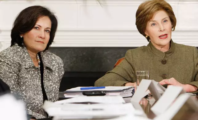 FILE - Anita McBride, left, Chief of Staff to first lady Laura Bush, right, looks on as Bush makes opening remarks during a video teleconference in the Roosevelt Room of the White House in Washington, Dec. 10, 2007. (AP Photo/Charles Dharapak, File)