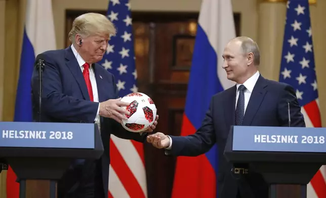 FILE - Russian President Vladimir Putin, right, gives a soccer ball to President Donald Trump during a press conference after their meeting at the Presidential Palace in Helsinki, Finland, July 16, 2018. (AP Photo/Alexander Zemlianichenko, File)