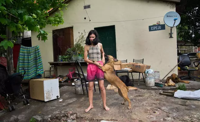 Abigail Rodriguez stands outside her home in the Isla Maciel neighborhood of Buenos Aires, Argentina, Friday, Oct. 24, 2025. (AP Photo/Rodrigo Abd)