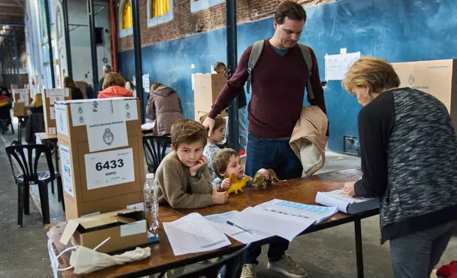 Patricio Irarrazabal arrives to vote with his sons during legislative midterm elections in Buenos Aires, Argentina, Sunday, Oct. 26, 2025. (AP Photo/Rodrigo Abd)