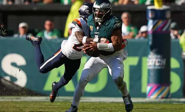 Denver Broncos cornerback Ja'Quan McMillian tackles Philadelphia Eagles quarterback Jalen Hurts during the second half of an NFL football game Sunday, Oct. 5, 2025, in Philadelphia. (AP Photo/Matt Rourke)