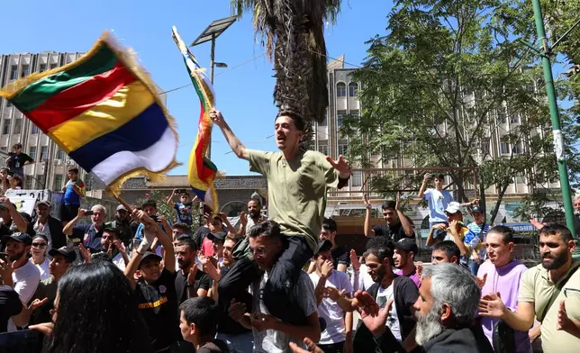 People chant slogans while waving the Druze flag during a weekly rally in Sweida, southern Syria, on Sept. 20, 2025. (AP Photo/Fahd Kiwan)