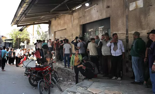 People line up for bread outside a bakery in Sweida, southern Syria, on Sept. 18, 2025.(AP Photo/Fahd Kiwan)