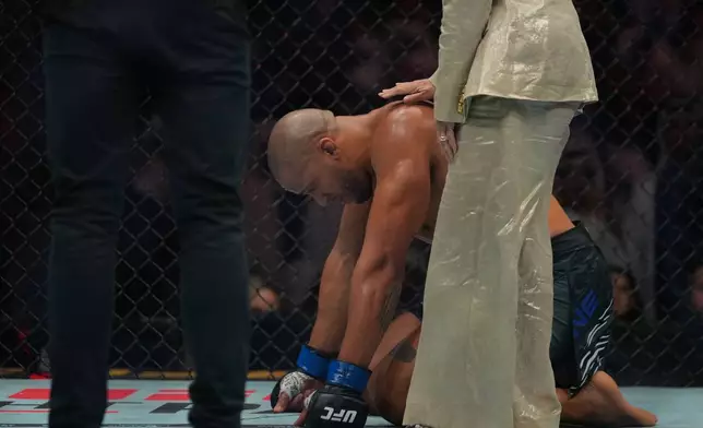 Ciryl Gane of France reacts after his fight with England's Tom Aspinall was called off during the heavyweight title bout at the UFC mixed martial arts Fight Night in Abu Dhabi, United Arab Emirates, Saturday, Oct. 25, 2025. (AP Photo/Altaf Qadri)