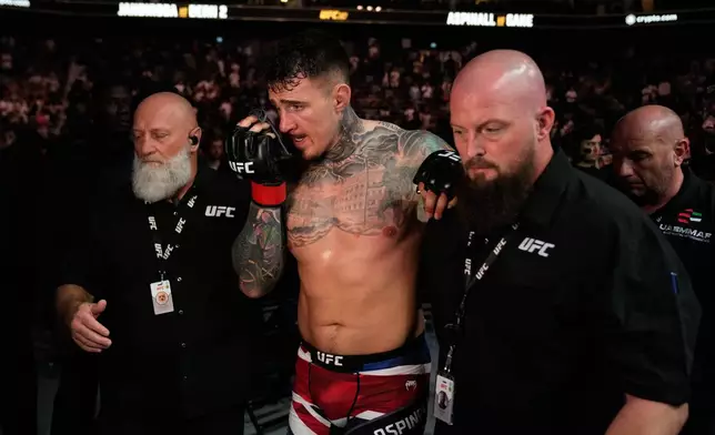 England's Tom Aspinall leaves after the fight was called off when his eyes were poked by Ciryl Gane of France during the heavyweight title bout at the UFC mixed martial arts Fight Night in Abu Dhabi, United Arab Emirates, Saturday, Oct. 25, 2025. (AP Photo/Altaf Qadri)