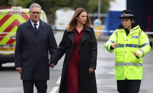 Britain's Prime Minister Keir Starmer, left, and his wife Victoria Starmer visit the site of the Manchester synagogue attack, in north Manchester, England, Friday Oct. 3, 2025. (Phil Noble/Pool Photo via AP)