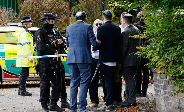 Members of the Jewish community speak to officers near to the Heaton Park Hebrew Congregation synagogue, in Crumpsall, Manchester, England, Thursday, Oct. 2, 2025 after Police reported that two people were killed and three others were seriously injured in a synagogue attack in northern England. (Peter Byrne/PA via AP)