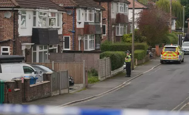 Police speak to a local resident close to the scene of a stabbing incident at Heaton Park Hebrew Congregation synagogue, in Crumpsall, Manchester, England, Thursday, Oct. 2, 2025. (AP Photo/Ian Hodgson)