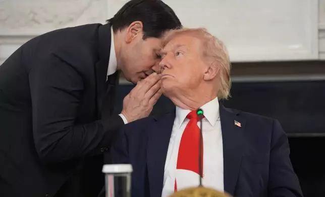 Secretary of State Marco Rubio whispers to President Donald Trump, who is holding the note Rubio handed to him, during a roundtable meeting on antifa in the State Dining Room at the White House, Wednesday, Oct. 8, 2025, in Washington. (AP Photo/Evan Vucci)