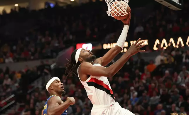 Portland Trail Blazers forward Jerami Grant (9) drives to the basket as Golden State Warriors forward Jimmy Butler III (10) defends during the first half of an NBA basketball game Friday, Oct. 24, 2025, in Portland, Ore. (AP Photo/Amanda Loman)