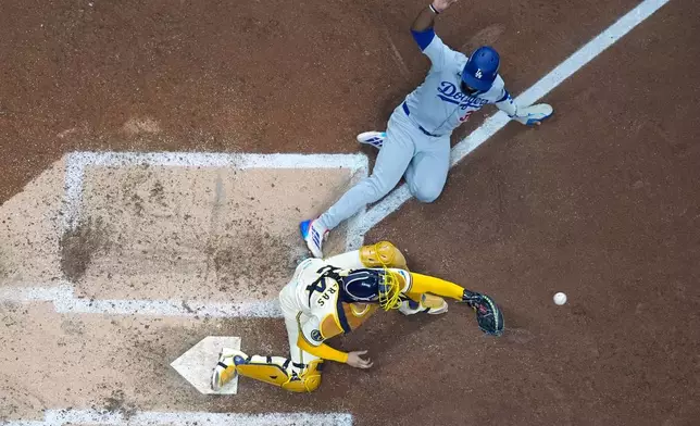 Los Angeles Dodgers' Teoscar Hernández is out at home as Milwaukee Brewers catcher William Contreras takes the throw during the fourth inning of Game 1 of baseball's National League Championship Series Monday, Oct. 13, 2025, in Milwaukee. (AP Photo/Morry Gash)