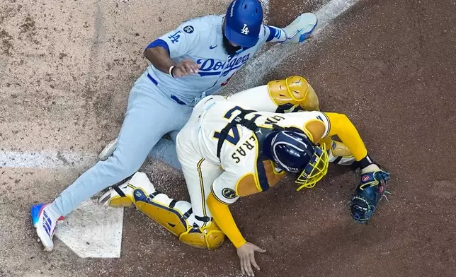 Los Angeles Dodgers' Teoscar Hernández is out at home as Milwaukee Brewers catcher William Contreras takes the throw during the fourth inning of Game 1 of baseball's National League Championship Series Monday, Oct. 13, 2025, in Milwaukee. (AP Photo/Morry Gash)