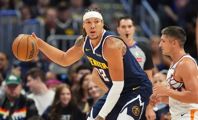 Denver Nuggets forward Aaron Gordon, left, looks to pass the ball as Phoenix Suns guard Grayson Allen, right, defends in the first half of an NBA basketball game Saturday, Oct. 25, 2025, in Denver. (AP Photo/David Zalubowski)