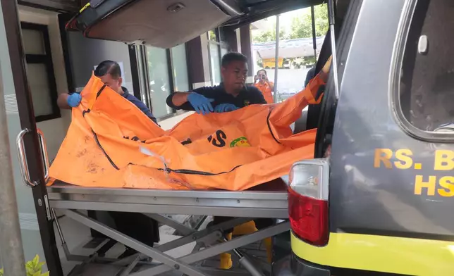 Rescuers remove the newly-recovered body of a victim of a building that collapsed at an Islamic boarding school from an ambulance upon arrival at the police hospital in Surabaya, East Java, Indonesia, Sunday, Oct. 5, 2025. (AP Photo/Trisnadi)