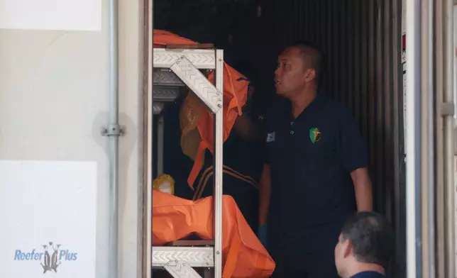 Rescuers arrange the bodies of the victims of a building that collapsed at an Islamic boarding school inside a refrigerated container at the police hospital in Surabaya, East Java, Indonesia, Sunday, Oct. 5, 2025. (AP Photo/Trisnadi)