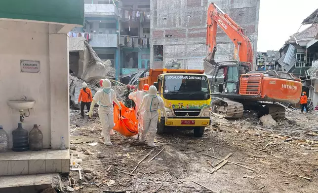 Rescuers carry the body of a newly recovered victim of a building that collapsed at an Islamic boarding school in Sidoarjo, East Java, Indonesia, Sunday, Oct. 5, 2025. (AP Photo/Trisnadi)
