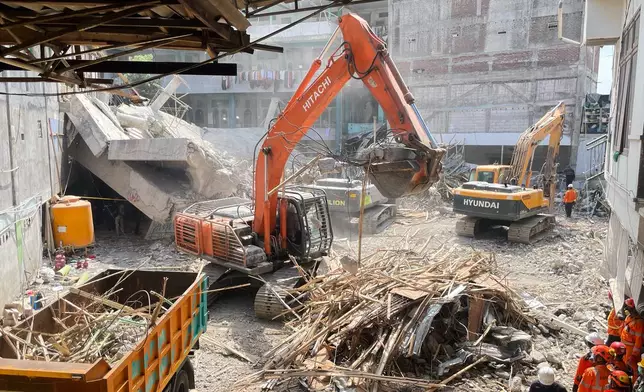 Rescuers use heavy machines to clear the rubble during the search for victims at a building that collapsed at an Islamic boarding school in Sidoarjo, East Java, Indonesia, Sunday, Oct. 5, 2025. (AP Photo/Trisnadi)