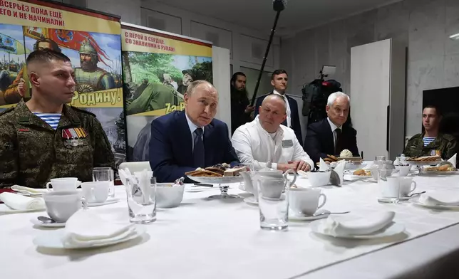 President Vladimir Putin, second left, talks servicemen, participants of a special military operation in Ukraine at the the Mandryk Central Military Clinical Hospital, in Moscow, Russia, Wednesday, Oct. 29, 2025. (Vyacheslav Prokofyev, Sputnik, Kremlin Pool Photo via AP)