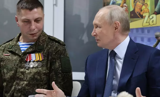 Russian President Vladimir Putin, right, talks with Russian servicemen who fought in Ukraine as he visits the Central Military Clinical Hospital, in Moscow, Russia, Wednesday, Oct. 29, 2025. (Vladimir Gerdo, Sputnik, Kremlin Pool Photo via AP)