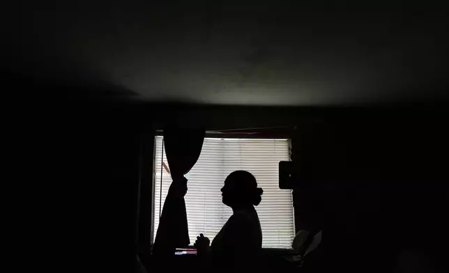 Paola Freites, who asked to be identified by her middle name and second last name to protect her family's safety, stands inside the two-bedroom mobile home where she lives with her husband and three children after fleeing persecution in their native Colombia, Thursday, Aug. 21, 2025, in Apopka, Fla. (AP Photo/Rebecca Blackwell)