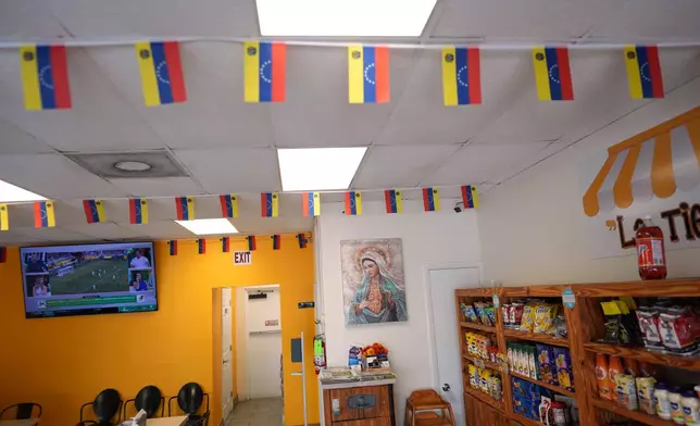 Venezuelan flags hang inside TeqaBite, a restaurant co-owned by two U.S. citizens born in Venezuela, in Kissimmee, Fla., Thursday, Aug. 21, 2025. (AP Photo/Rebecca Blackwell)