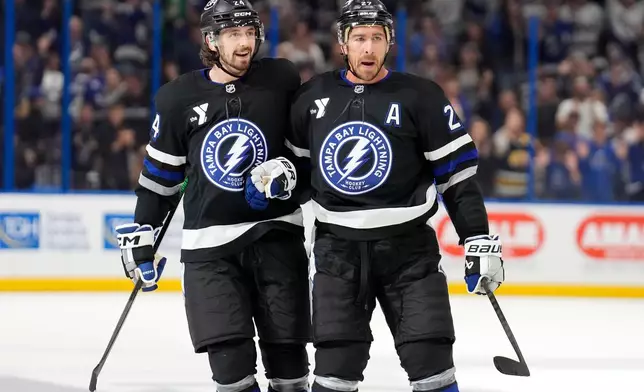 Tampa Bay Lightning defenseman Ryan McDonagh, right, celebrates his goal against the New Jersey Devils with defenseman Max Crozier during the second period of an NHL hockey game Saturday, Oct. 11, 2025, in Tampa, Fla. (AP Photo/Chris O'Meara)